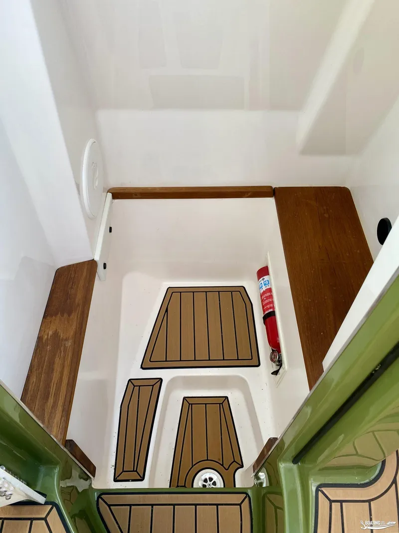 Slide: The Image of 2022 MasterCraft X26 boat interior with teak flooring and fire extinguisher. - 18