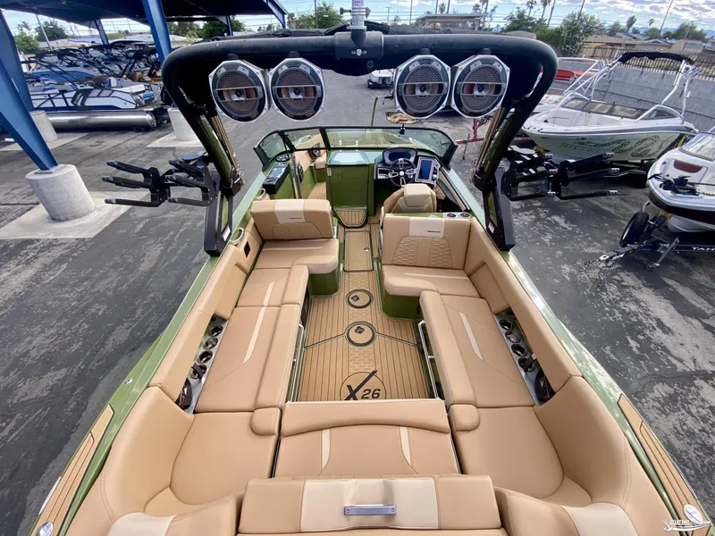 Slide: The Image of 2022 MasterCraft X26 boat interior with tan seating and advanced audio system. - 7