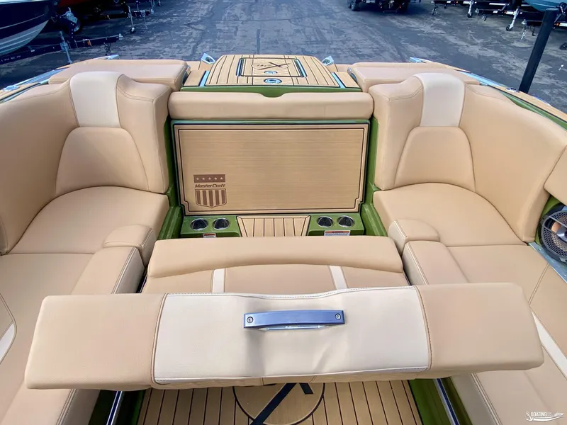 Slide: The Image of 2022 MasterCraft X26 boat interior with beige seating and wood accents. - 9