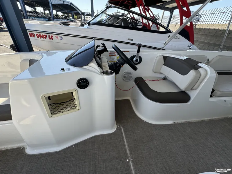 Slide: The Image of 2020 Bayliner E21 boat interior with steering console and seating area. - 12