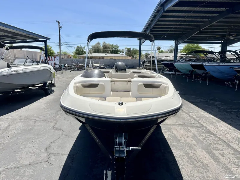 Slide: The Image of 2020 Bayliner E21 boat on trailer in a marina storage area. - 2