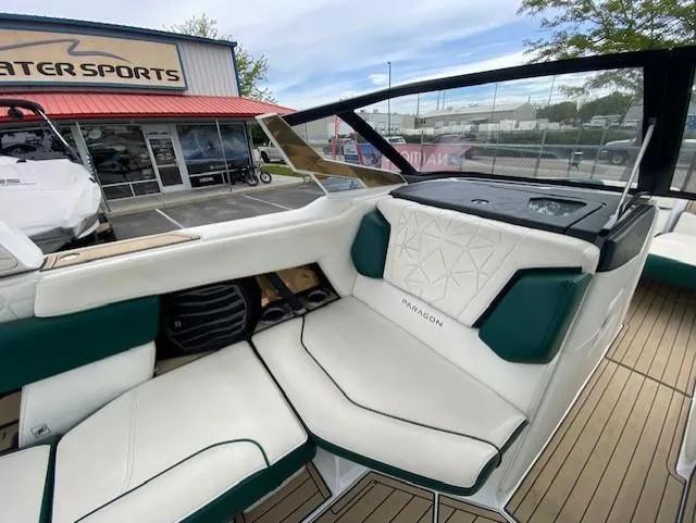 Slide: The Image of 2020 Nautique PARAGON 23 boat interior with white and green seating at a dealership. - 12