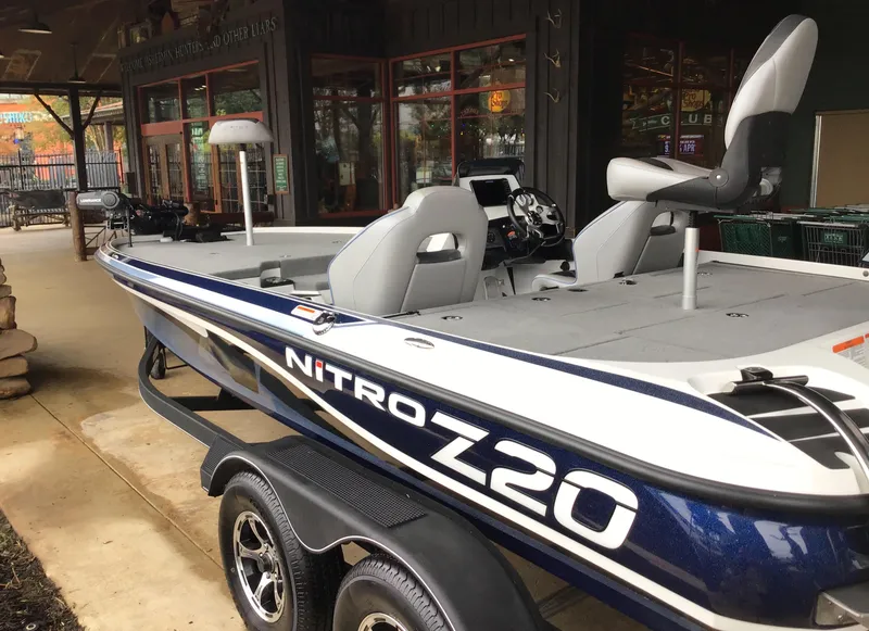Slide: The Image of 2024 Nitro Z20 Pro fishing boat on trailer, parked outside a store. - 2
