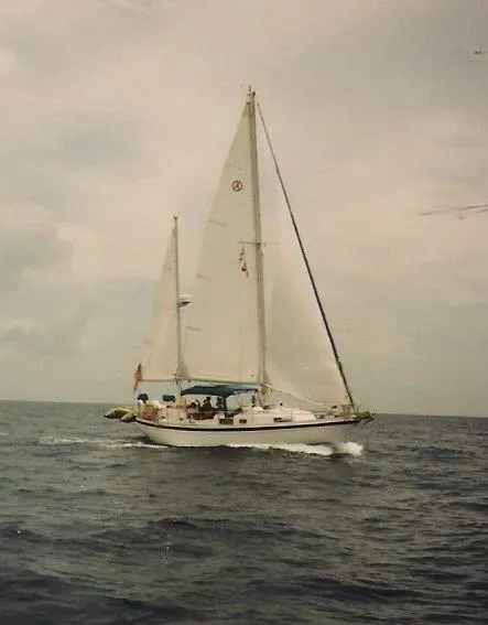 Slide: The Image of 1975 Allied Mistress sailboat cruising on open sea under cloudy skies. - 0