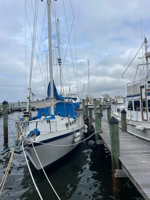 Slide: The Image of 1975 Allied Mistress sailboat docked at a marina on a cloudy day. - 1