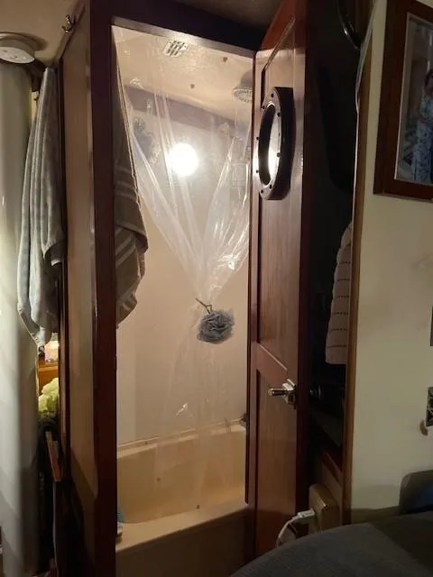 Slide: The Image of 1975 Allied Mistress boat shower with porthole and hanging towels. - 10