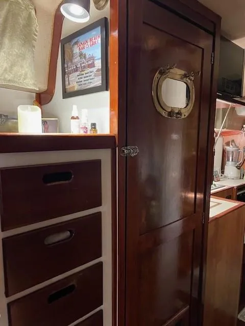 Slide: The Image of 1975 Allied Mistress yacht interior with wooden cabinets and porthole door. - 12