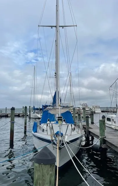 Slide: The Image of 1975 Allied Mistress sailboat docked at a marina on a cloudy day. - 13