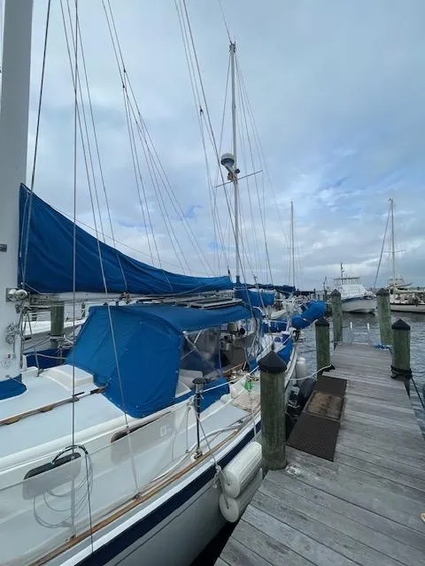 Slide: The Image of 1975 Allied Mistress sailboat docked at a marina with blue covers. - 16