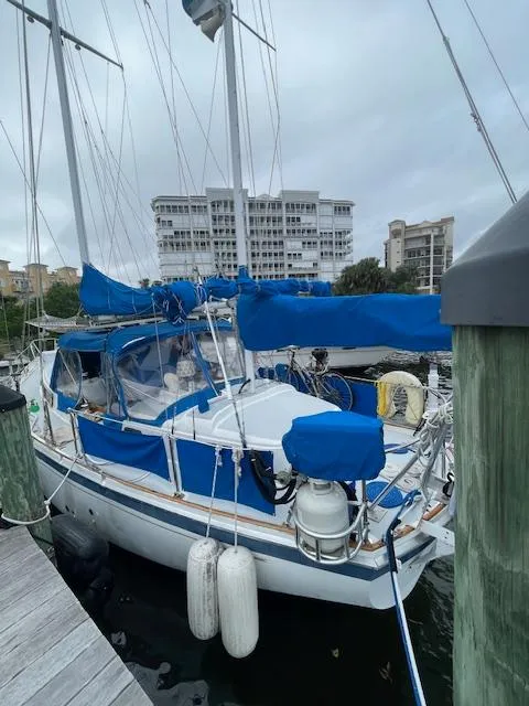 Slide: The Image of 1975 Allied Mistress sailboat docked at marina with blue covers and rigging. - 2