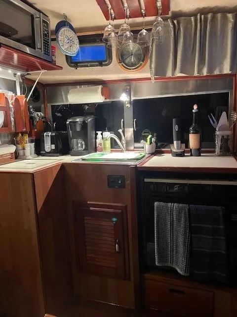 Slide: The Image of Cozy 1975 Allied Mistress boat kitchen with wooden cabinets and modern appliances. - 3