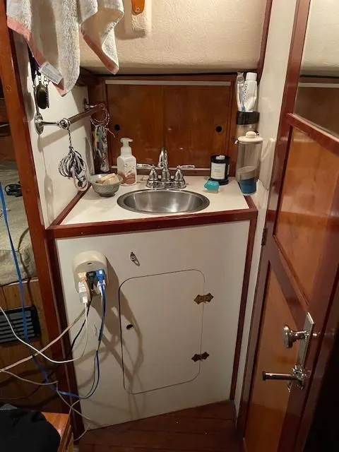 Slide: The Image of 1975 Allied Mistress boat interior with compact sink and storage area. - 5