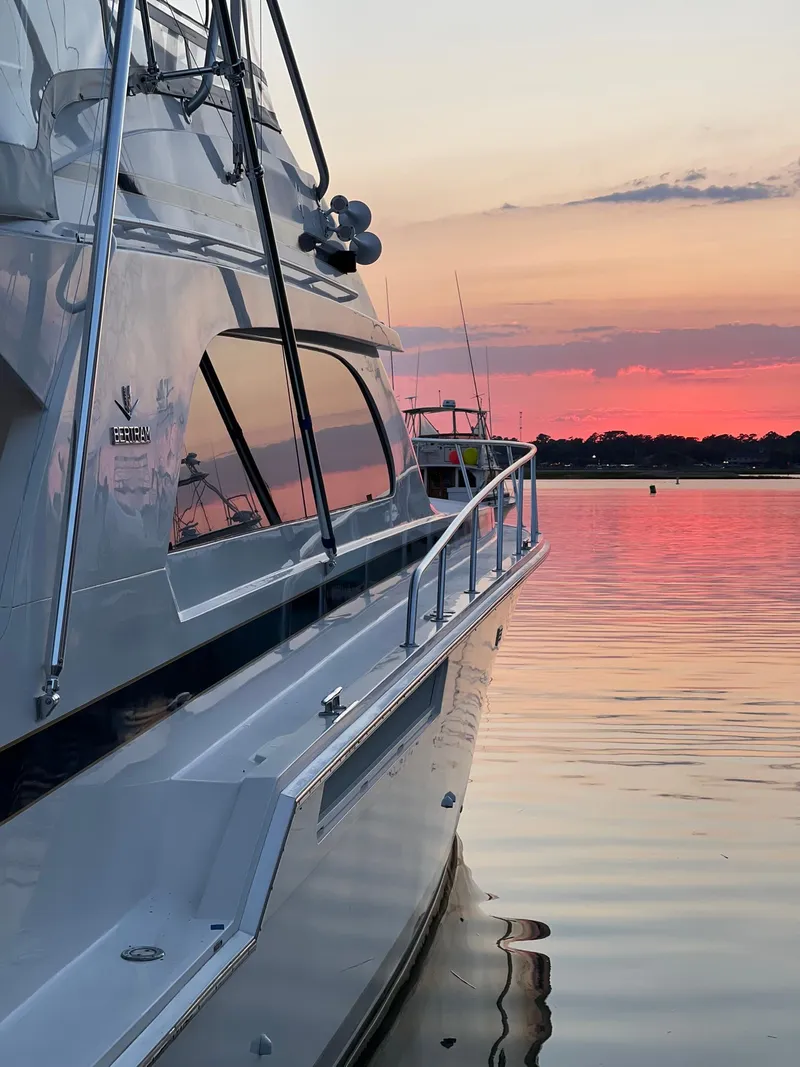 Slide: The Image of 1999 Bertram 60 Convertible yacht at sunset on calm waters. - 12