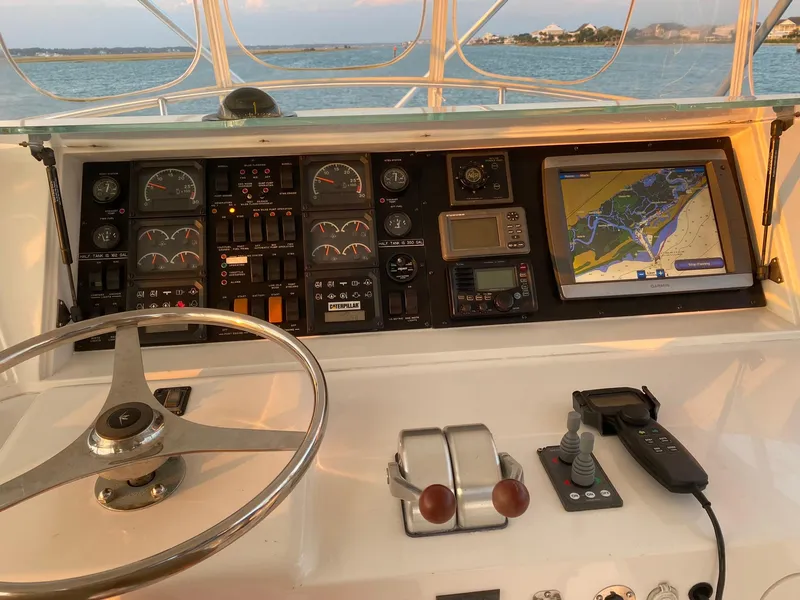 Slide: The Image of 1999 Bertram 60 Convertible yacht dashboard with navigation system and controls. - 19