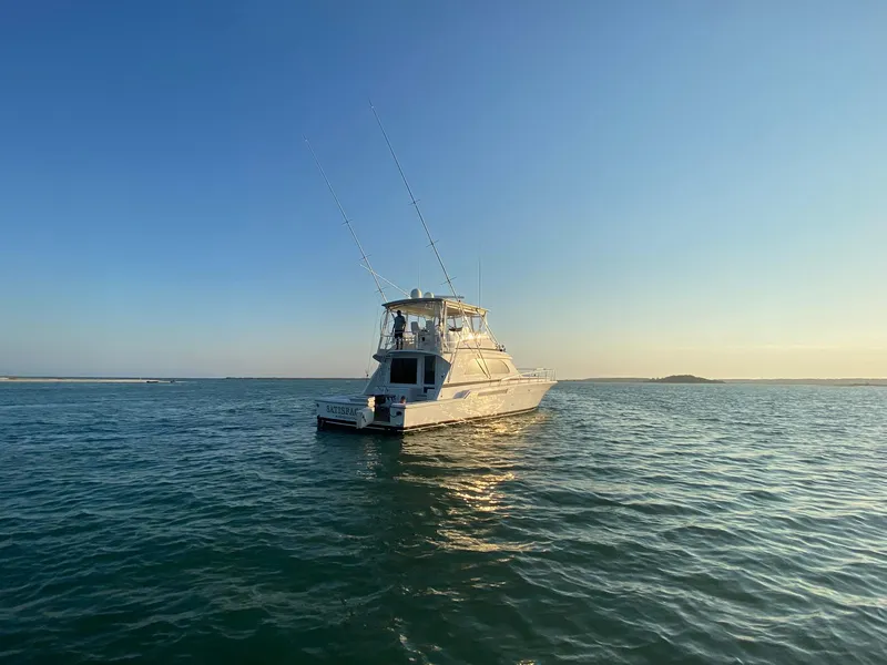 Slide: The Image of 1999 Bertram 60 Convertible yacht on open water at sunset. - 20