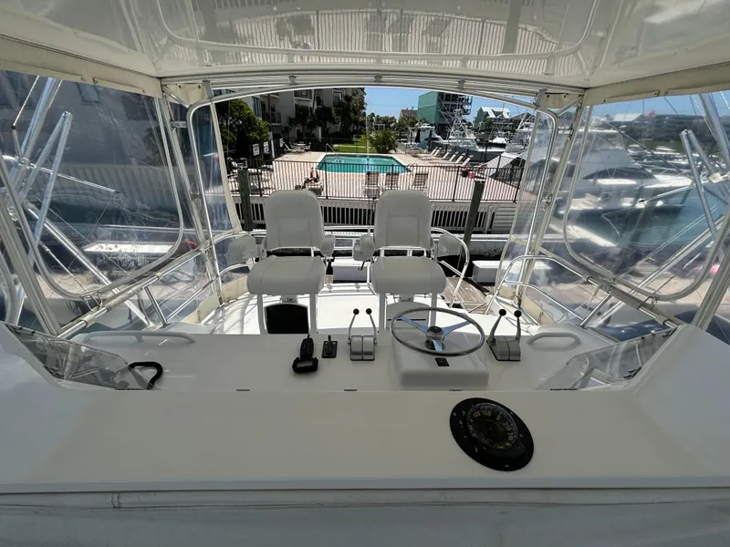 Slide: The Image of 1999 Bertram 60 Convertible yacht helm station with dual captain chairs and navigation controls. - 24
