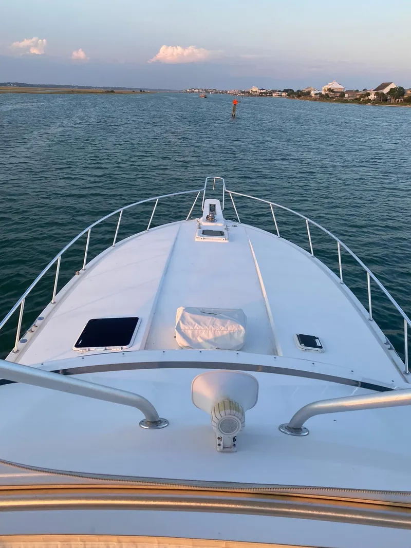 Slide: The Image of 1999 Bertram 60 Convertible yacht cruising on calm waters. - 29