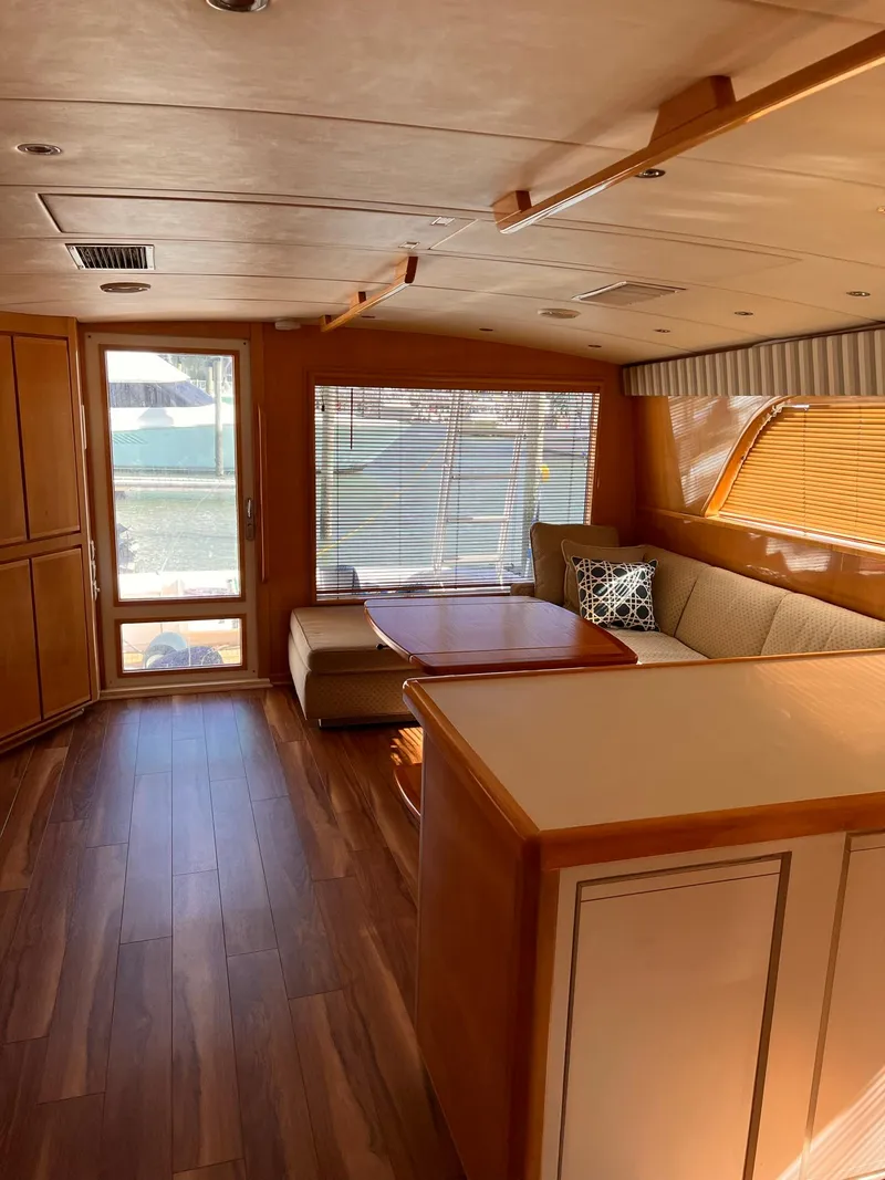 Slide: The Image of Interior of a 1999 Bertram 60 Convertible yacht with wooden flooring and cozy seating area. - 33
