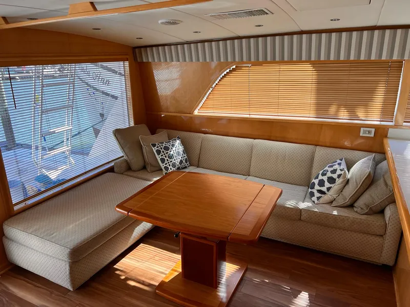 Slide: The Image of Interior of 1999 Bertram 60 Convertible yacht with cozy seating and wooden table. - 35