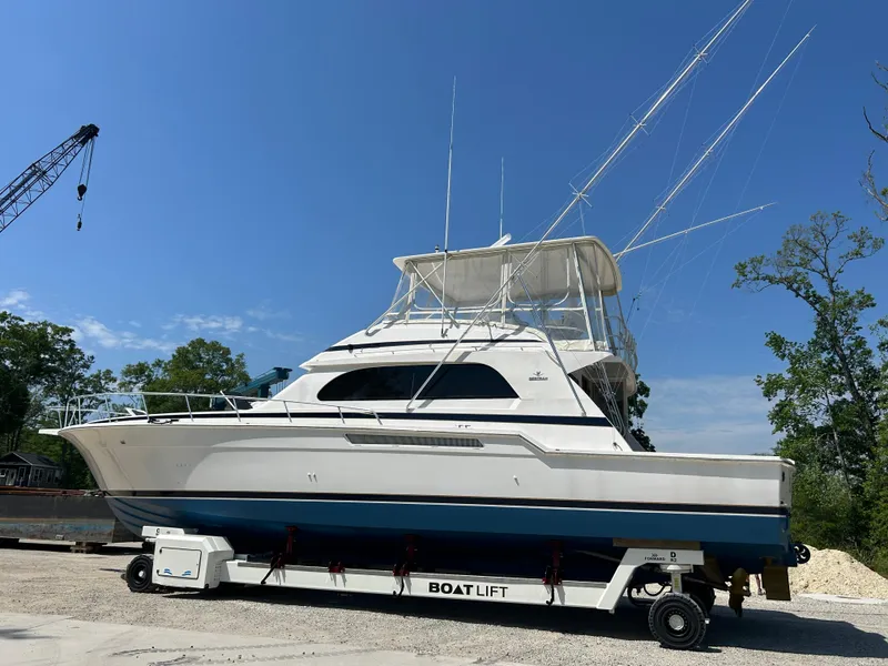 Slide: The Image of 1999 Bertram 60 Convertible yacht on a boat lift, clear sky background. - 4