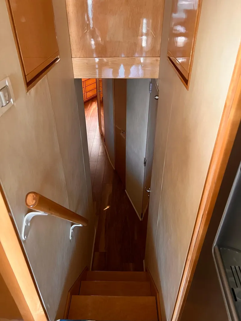 Slide: The Image of Staircase inside a 1999 Bertram 60 Convertible yacht with wooden handrails and walls. - 41