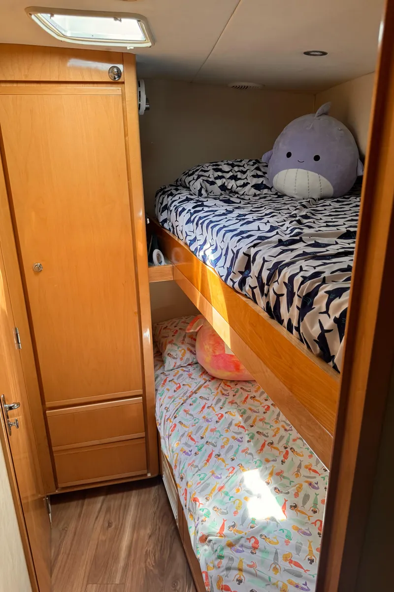 Slide: The Image of Bunk beds in the 1999 Bertram 60 Convertible cabin with plush toys and wooden cabinetry. - 46