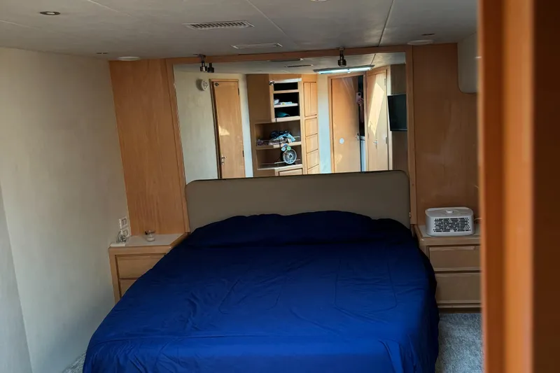 Slide: The Image of Bedroom interior of a 1999 Bertram 60 Convertible yacht with blue bedding. - 49