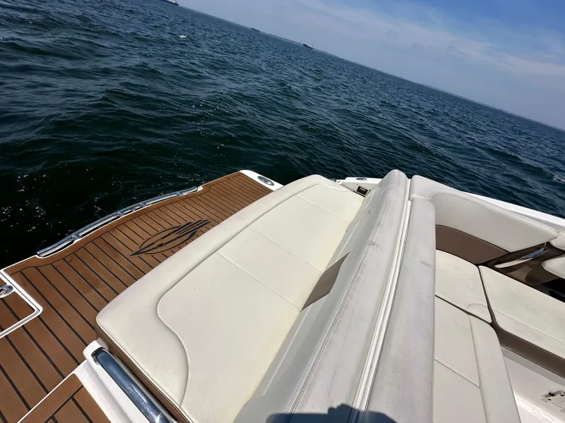 Slide: The Image of 2014 Chaparral 307 SSX boat with white seating and wooden deck on open water. - 23