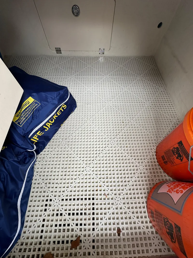 Slide: The Image of Storage compartment of a 2014 Chaparral 307 SSX boat with life jackets and safety equipment. - 28