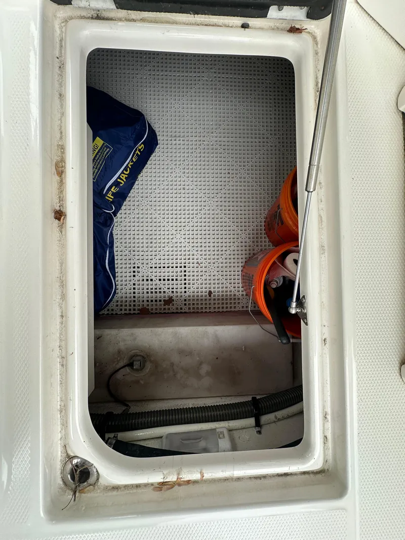 Slide: The Image of Storage compartment of a 2014 Chaparral 307 SSX boat with life jackets and buckets. - 29