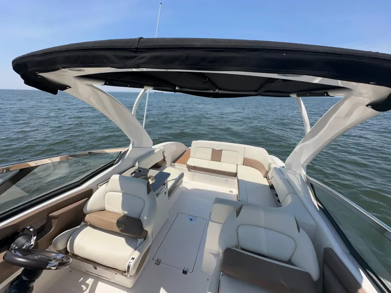 Slide: The Image of 2014 Chaparral 307 SSX boat interior with seating and canopy on open water. - 8