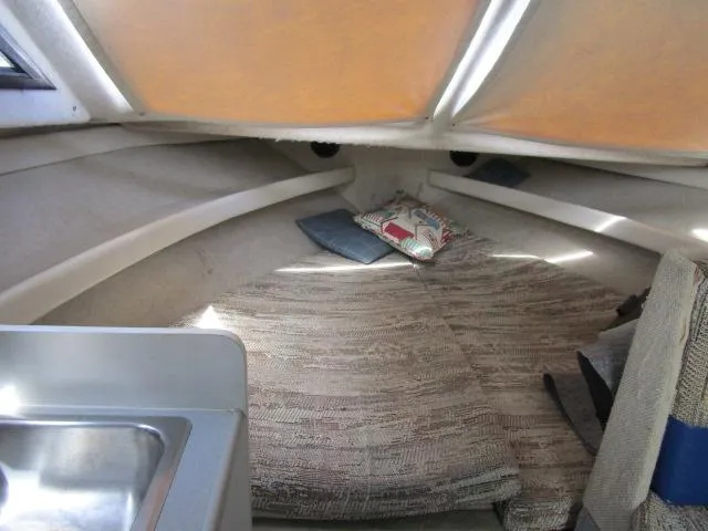 Slide: The Image of 1994 Bayliner 2452 Classic cabin interior with bed and sink. - 12