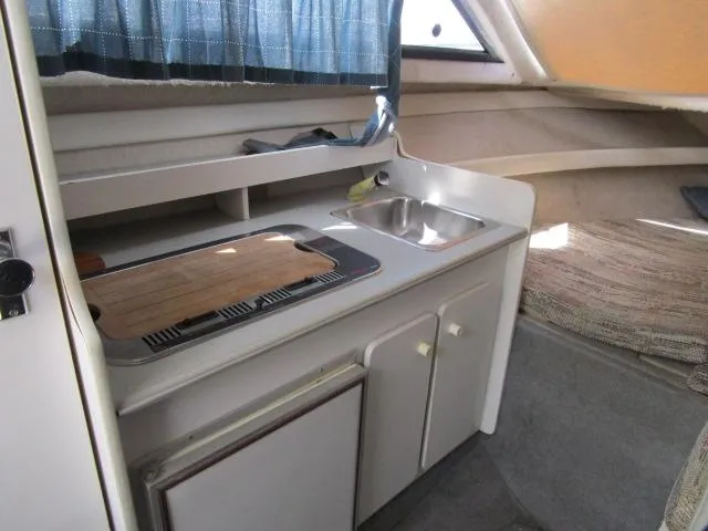Slide: The Image of 1994 Bayliner 2452 Classic boat interior kitchen with sink and stove. - 14