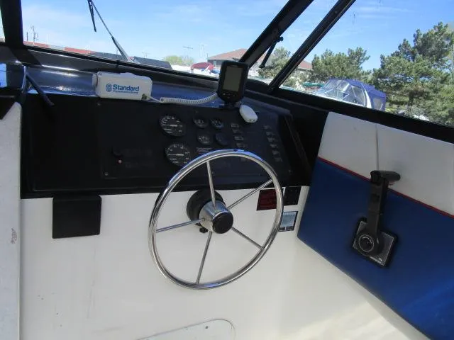 Slide: The Image of 1994 Bayliner 2452 Classic boat helm with steering wheel and instrument panel. - 5