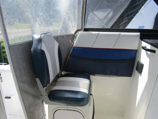 Slide: The Image of 1994 Bayliner 2452 Classic boat interior seating area with blue and white upholstery. - 6