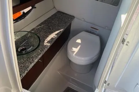 Slide: The Image of 2024 Crownline 290 SS boat bathroom with granite countertop and modern fixtures. - 6