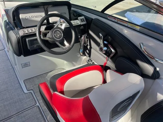 Slide: The Image of 2024 Crownline 290 SS boat cockpit with Garmin navigation system and red and white captain's chair. - 7