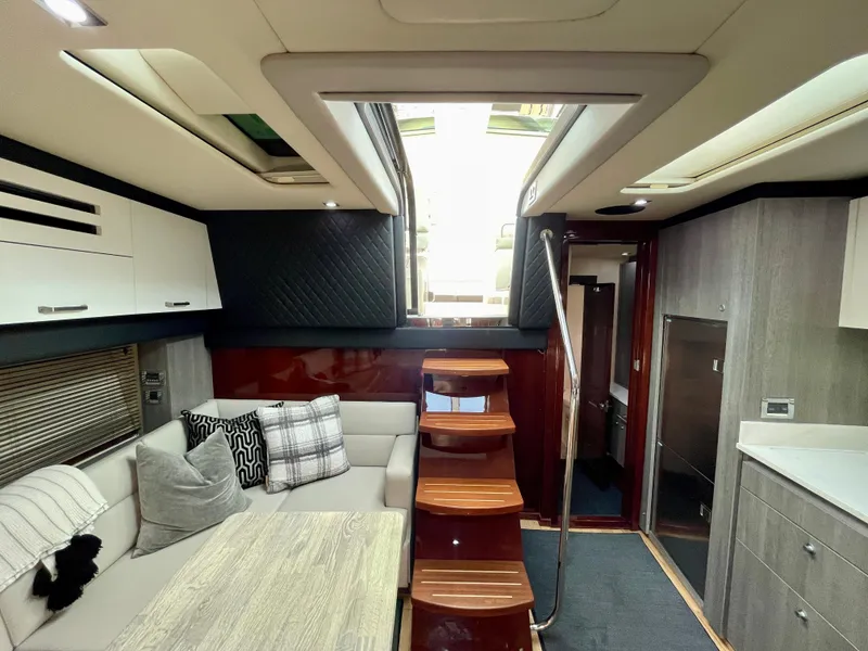 Slide: The Image of Interior of 2009 Sea Ray 470 Sundancer yacht with modern seating and wooden stairs. - 14