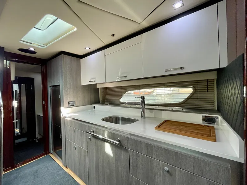 Slide: The Image of Modern kitchen area in a 2009 Sea Ray 470 Sundancer yacht with sleek cabinetry and skylight. - 28