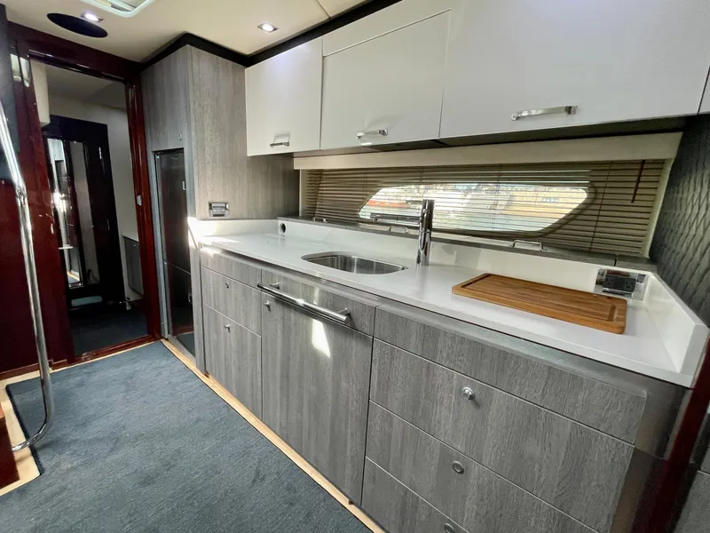 Slide: The Image of Modern kitchen area in a 2009 Sea Ray 470 Sundancer yacht with sleek cabinetry and stainless steel fixtures. - 29