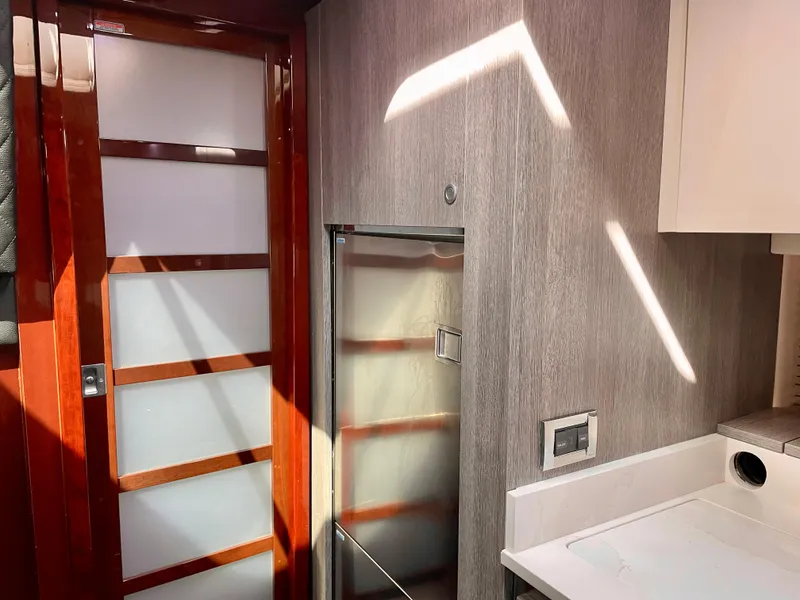 Slide: The Image of Interior of 2009 Sea Ray 470 Sundancer with modern kitchen and wooden door. - 38