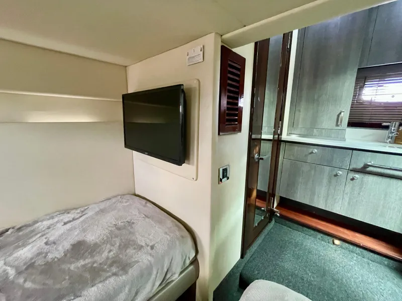Slide: The Image of 2009 Sea Ray 470 Sundancer cabin interior with TV and kitchenette. - 44