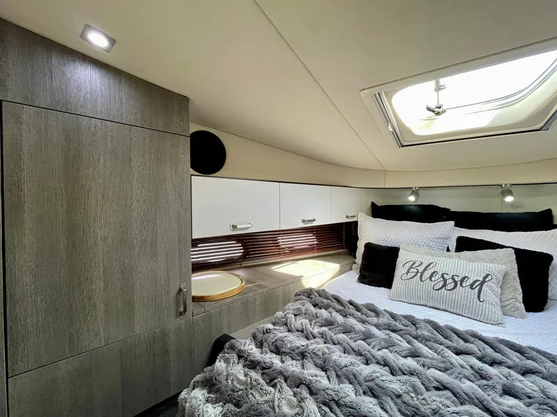 Slide: The Image of Luxurious bedroom interior of 2009 Sea Ray 470 Sundancer yacht with skylight and cozy bedding. - 46