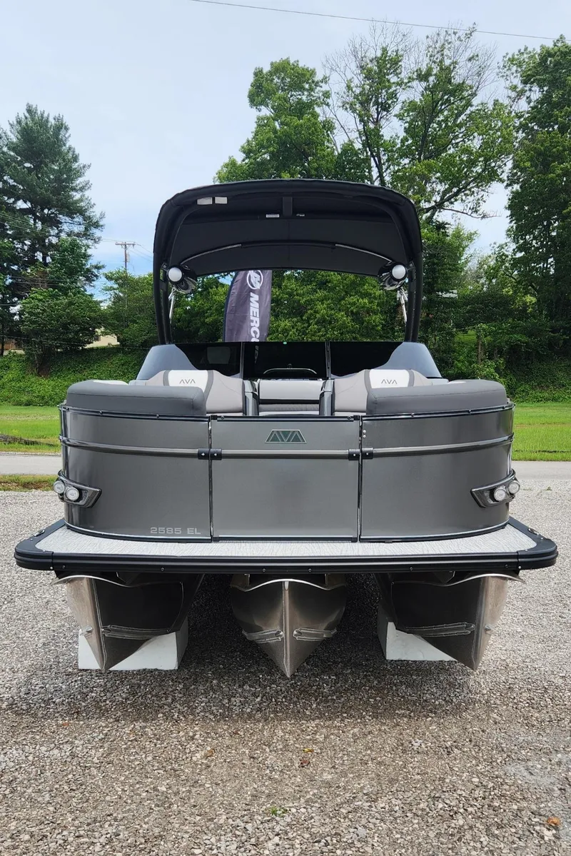 Slide: The Image of 2024 Avalon Windshield Catalina 2585 pontoon boat, rear view, parked on gravel. - 2