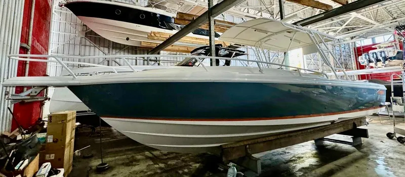 The Image of 2003 Intrepid 322 Cuddy boat in storage, side view, blue hull, indoor facility. - 0