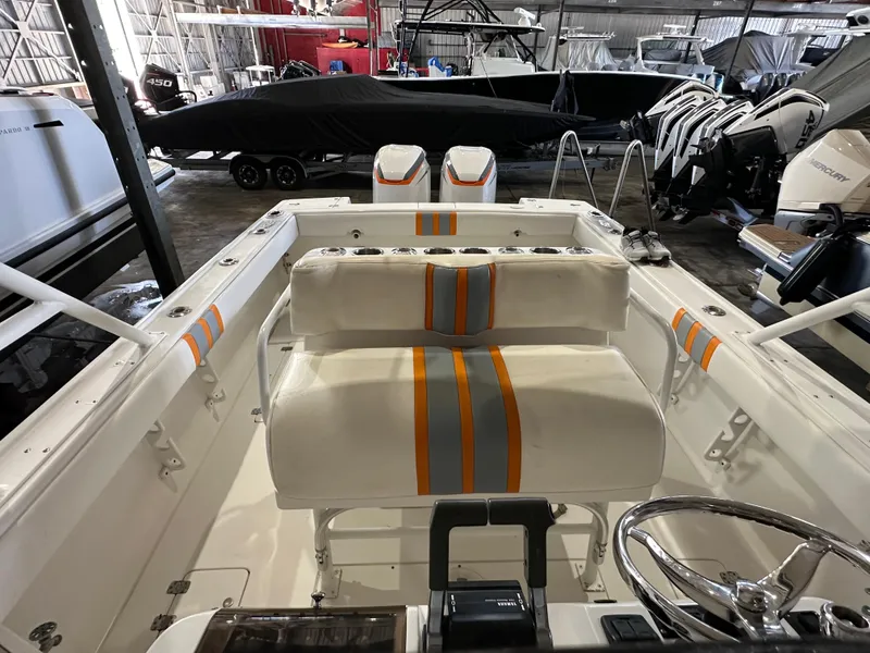 Slide: The Image of 2003 Intrepid 322 Cuddy boat interior with striped seating in a storage facility. - 10