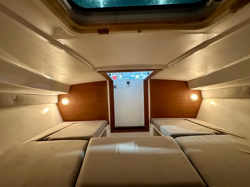 Slide: The Image of 2003 Intrepid 322 Cuddy cabin interior with cozy lighting and cushioned seating. - 5