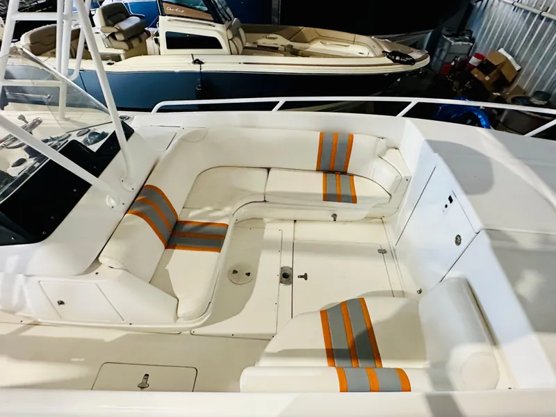 Slide: The Image of 2003 Intrepid 322 Cuddy boat interior with white and orange-striped seating. - 6