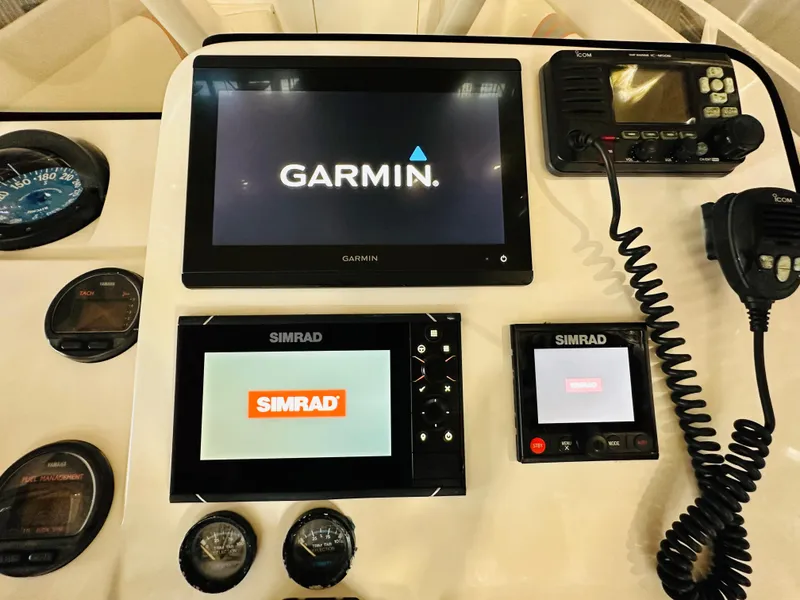 Slide: The Image of 2003 Intrepid 322 Cuddy dashboard with Garmin and Simrad navigation systems. - 7