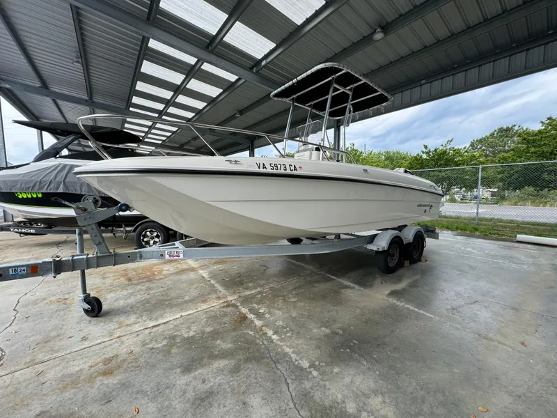 Slide: The Image of 2017 Bayliner Element F21 boat on a trailer under a metal canopy. - 0